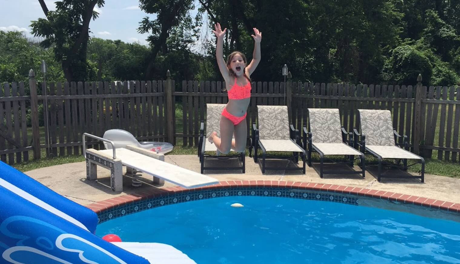 Image of child jumping into a crystal blue pool